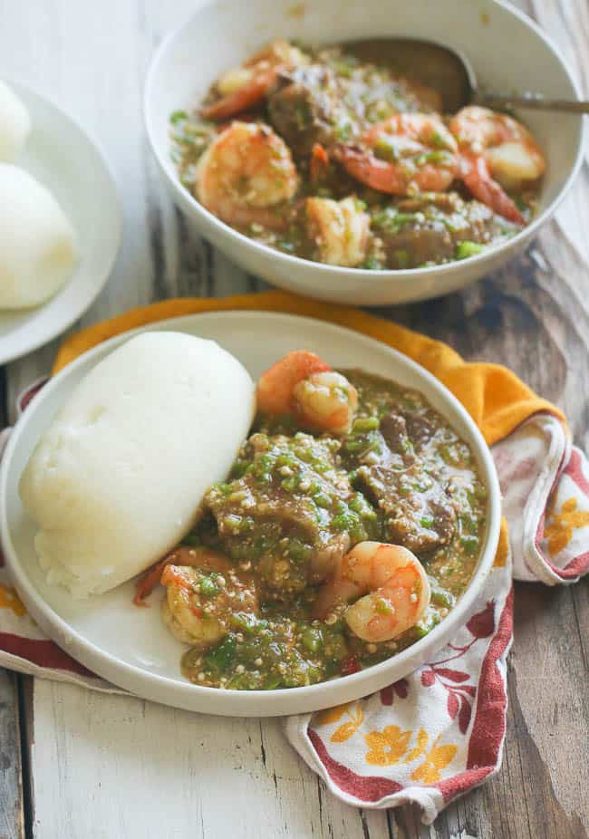 Serving up two bowls of mouthwatering okra soup with fufu