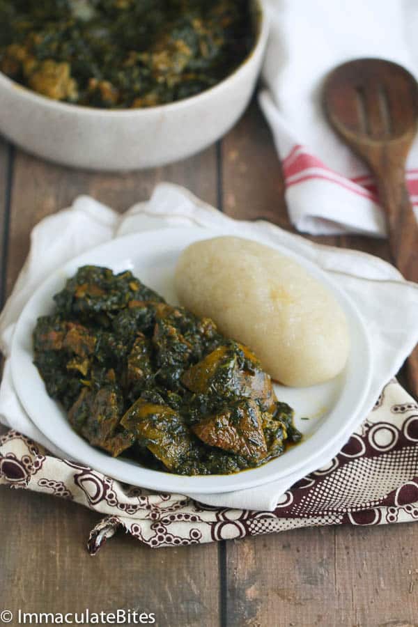 Eru Soup (Spinach/Okazi Leaves) a serving of Eru Soup(Spinach/Okazi leaves) with fufu on a white plate