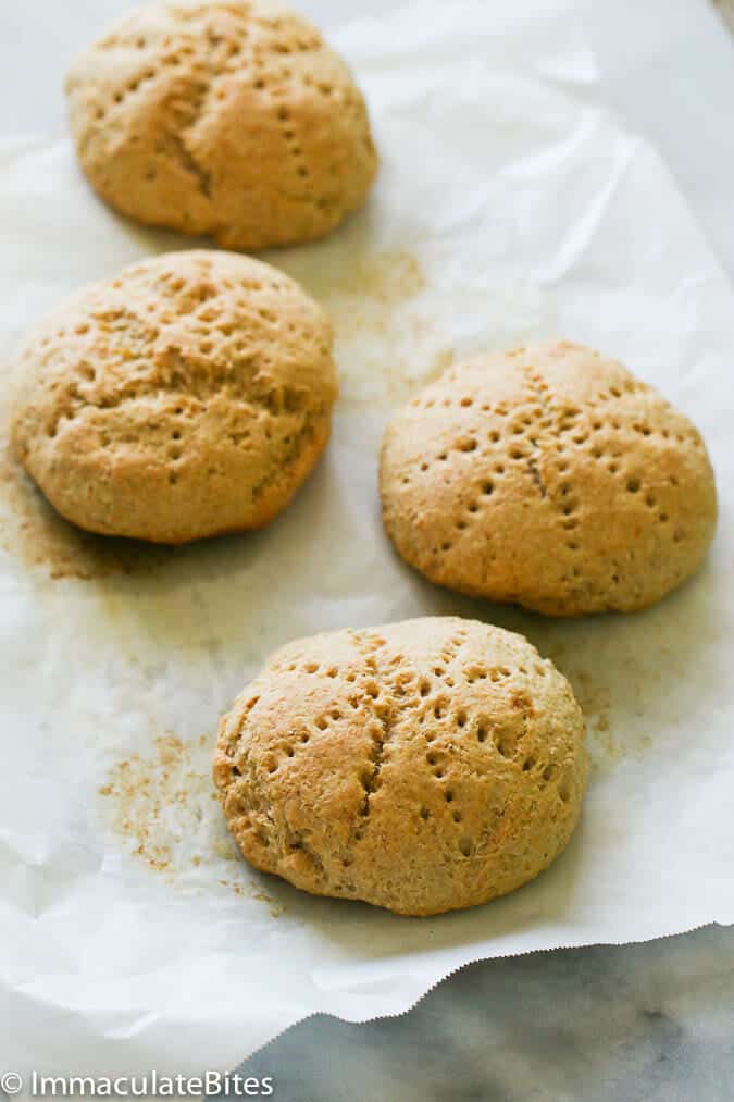 Freshly baked coconut bakes (coconut bread) cooling on parchment paper