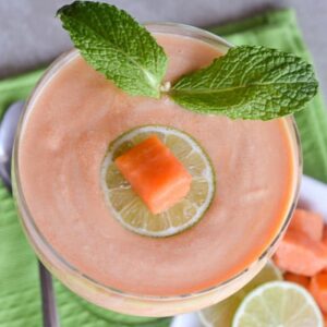 A refreshing papaya fool decorated with a papaya cube and mint leaves