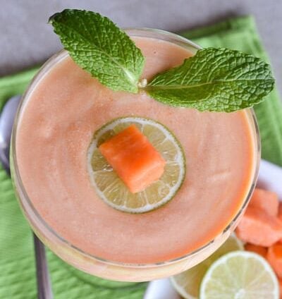 A refreshing papaya fool decorated with a papaya cube and mint leaves