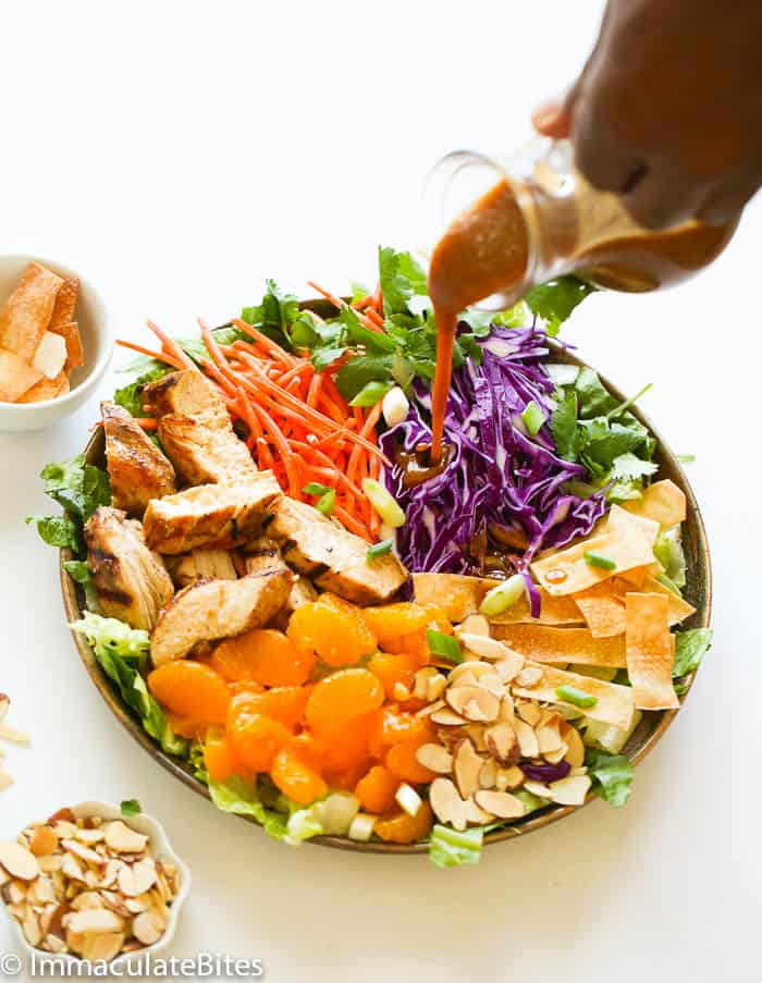 Drizzling amazing dressing over a healthy Asian chicken salad