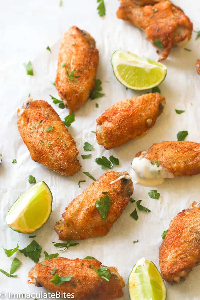 Crispy baked chicken wings with lime wedges