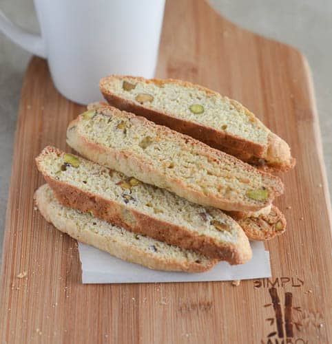 Banana Biscotti stacked up on a napkin with a cup of coffee in the background