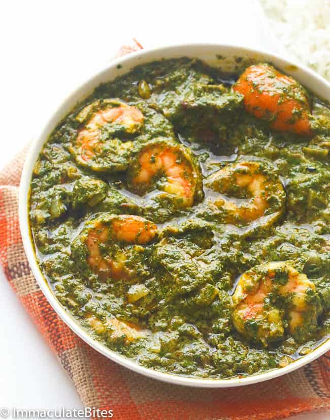 Cassava leaf soup with shrimp in a white bowl.