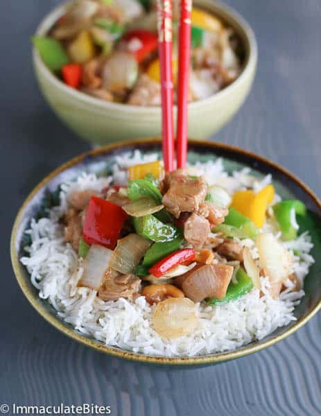 Enjoying a steaming hot plateful of Asian cashew chicken with red chopsticks