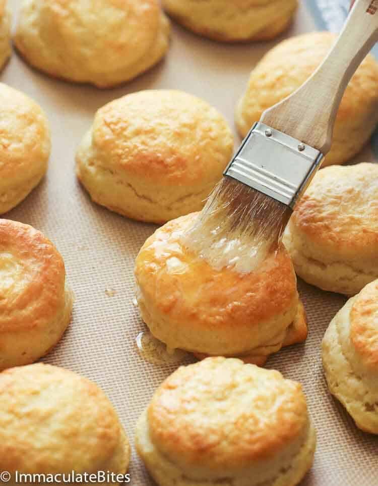 Brushing fresh-from-the-oven angel biscuits with butter
