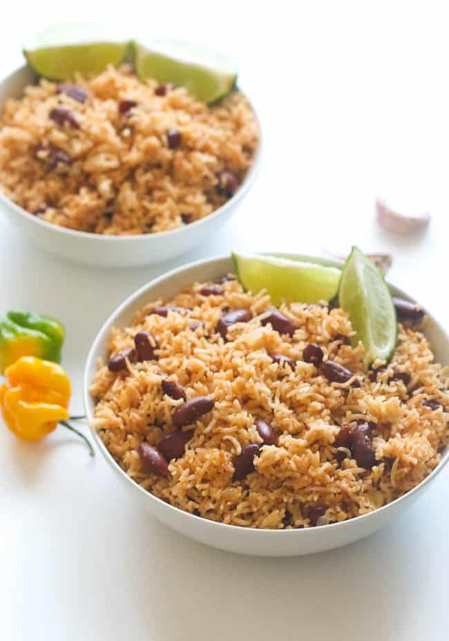 Two Bowls of Caribbean Style Rice and Beans Served with Lime Wedges