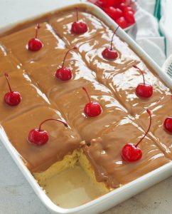 Cuatro Leches Cake sliced and ready to impress with cherries on top
