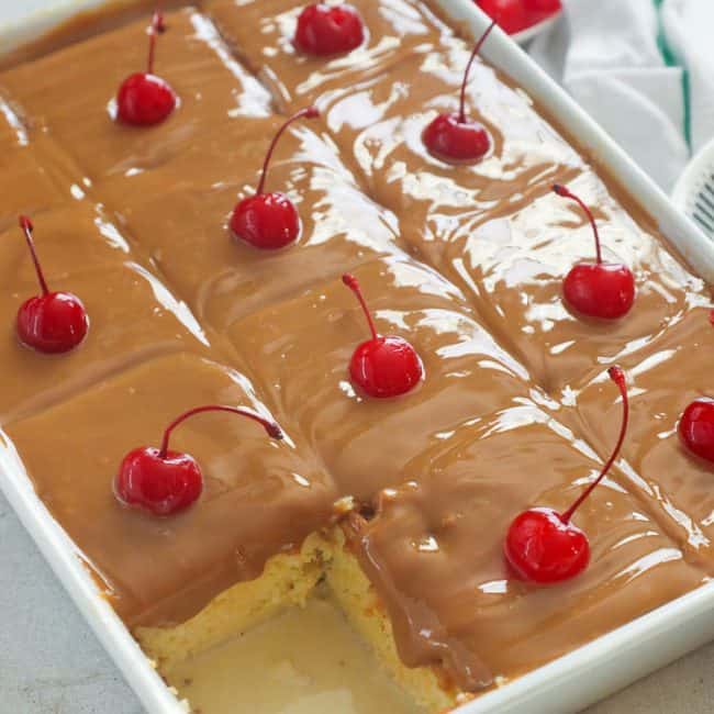 Cuatro Leches Cake sliced and ready to impress with cherries on top