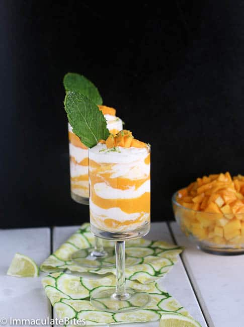 Two glasses of parfait like mango fool with mint leaves