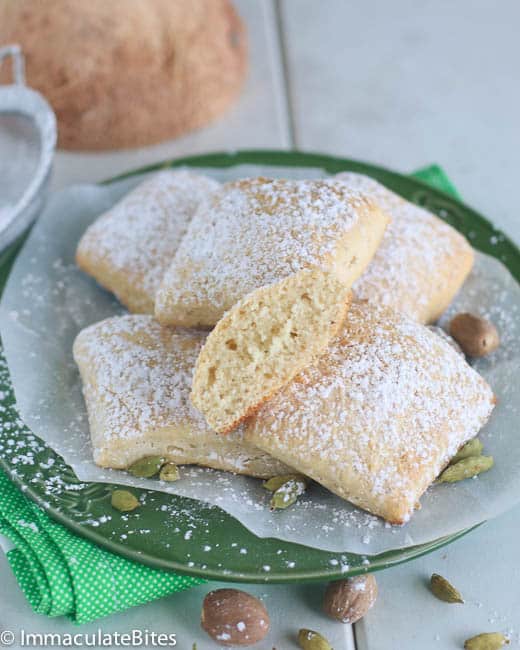 Enjoying a plateful of soft baked mandazi dusted with powdered sugar