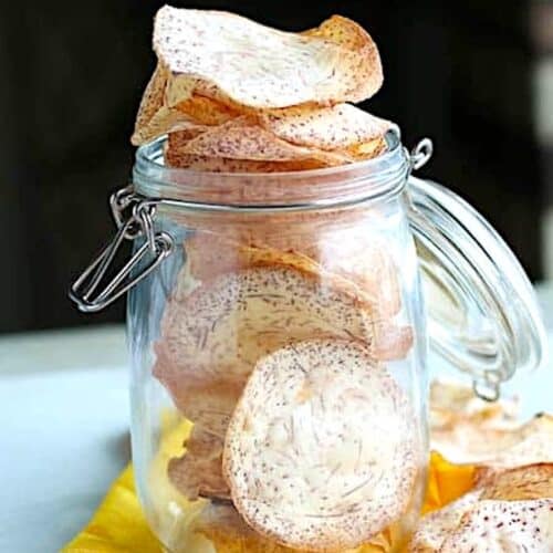 A glass jar full of freshly made taro chips for a healthy snack