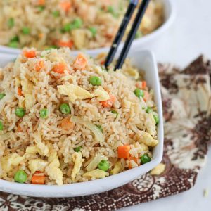 Coconut fried rice in a square white bowl with chopsticks
