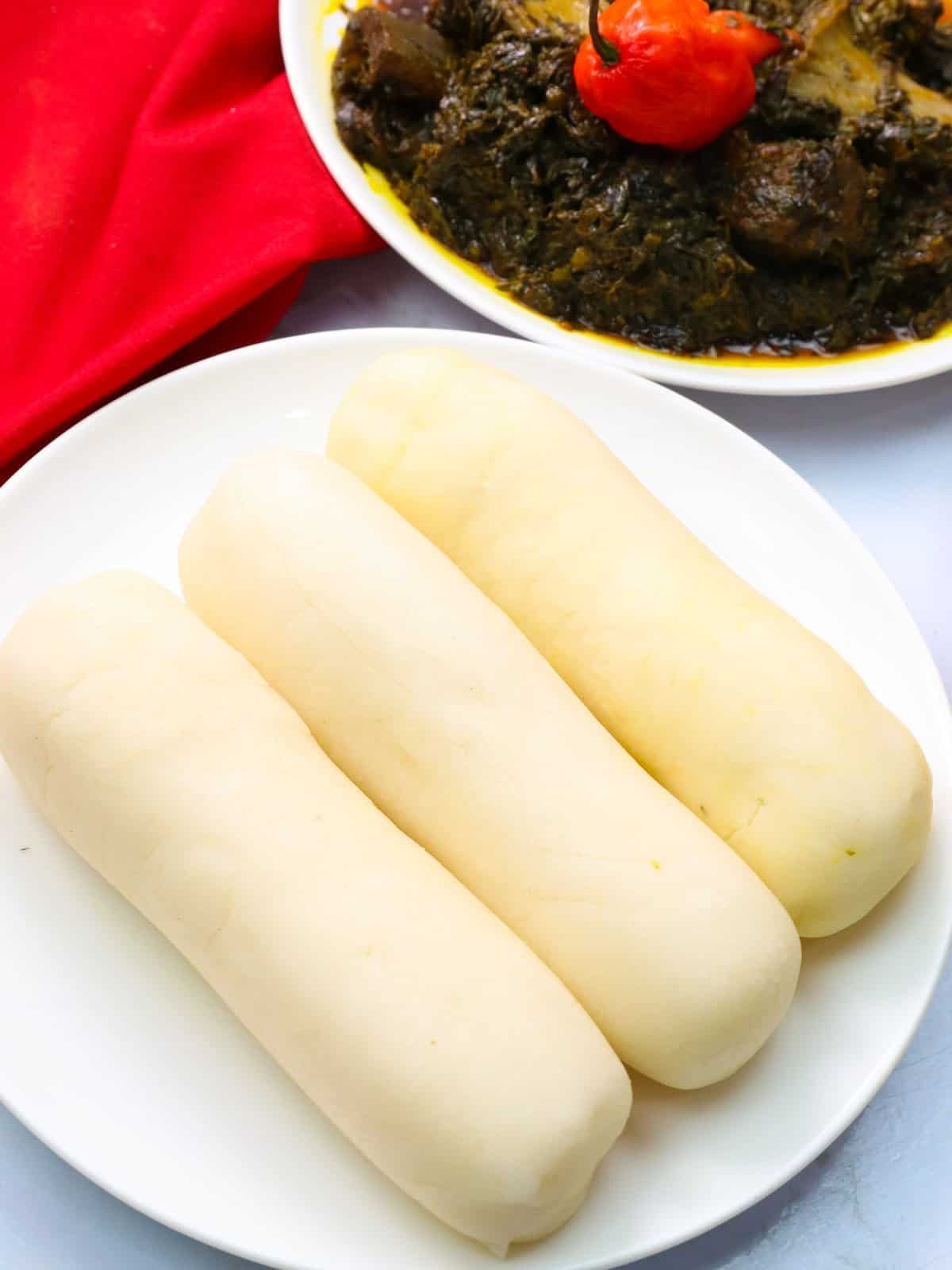 three logs of cassava fufu on a white plate