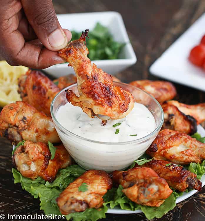 Dipping healthy chicken wings shawarma into low-fat ranch dressing
