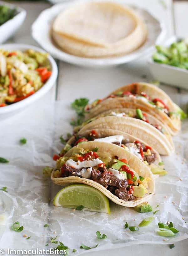 Enjoying Korean Beef Tacos with more corn tortillas in the background