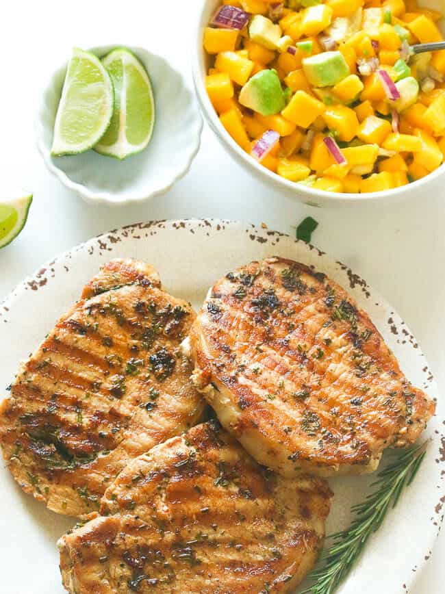 Enjoying a super juicy marinated pork chop with a side of mango salsa