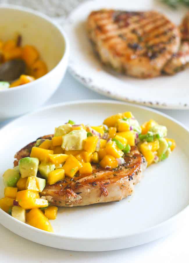 Serving up a freshly grilled marinated pork chop with mango salsa