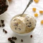 Rum raisin pineapple ice cream in a bowl with a spoon