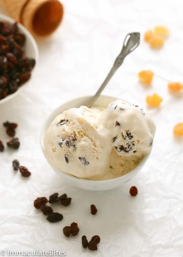 Two Scoops of Rum Raisin Pineapple Ice Cream with Raisins in the Background
