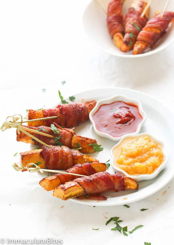 Bacon-wrapped plantain with hot sauces on a white plate