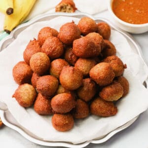 A plateful of banana fritters with sauce