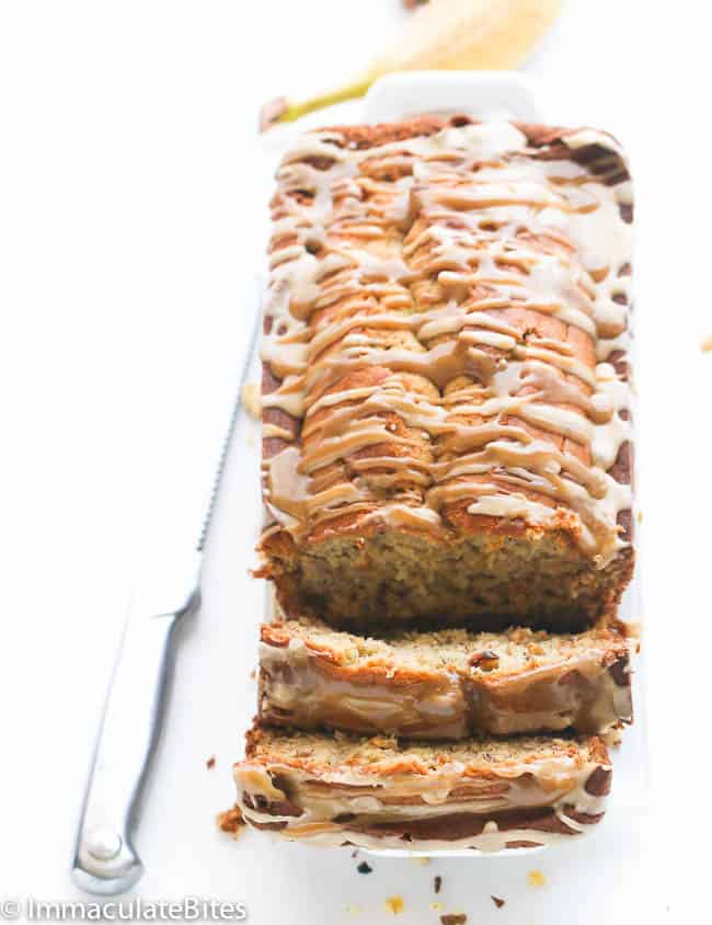 Caribbean banana nut bread drizzled with glaze and sliced