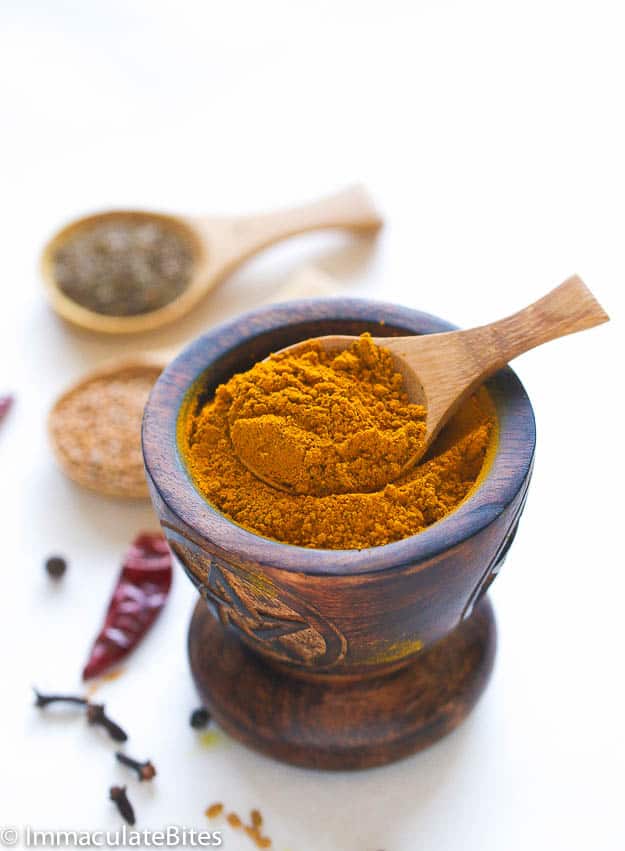 Jamaican Curry in a mortar and pestle with dried hot pepper in the background