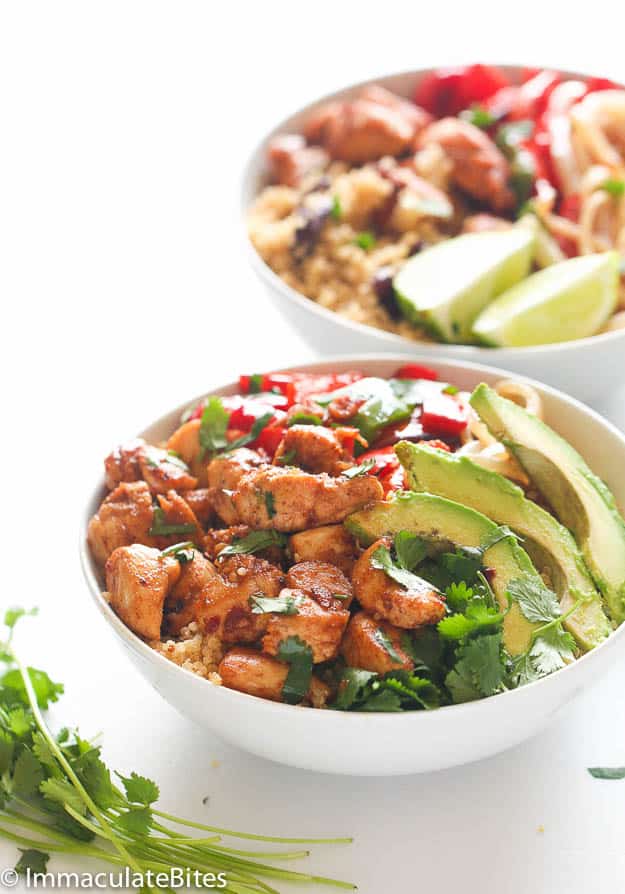 Serving up two delicious bowls of quinoa and beans with avocado slices and stir-fried chicken