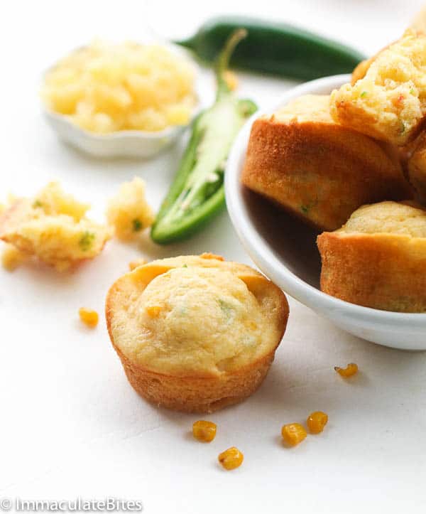 A plate full of Pineapple Jalapeños Corn Muffins with one ready to eat
