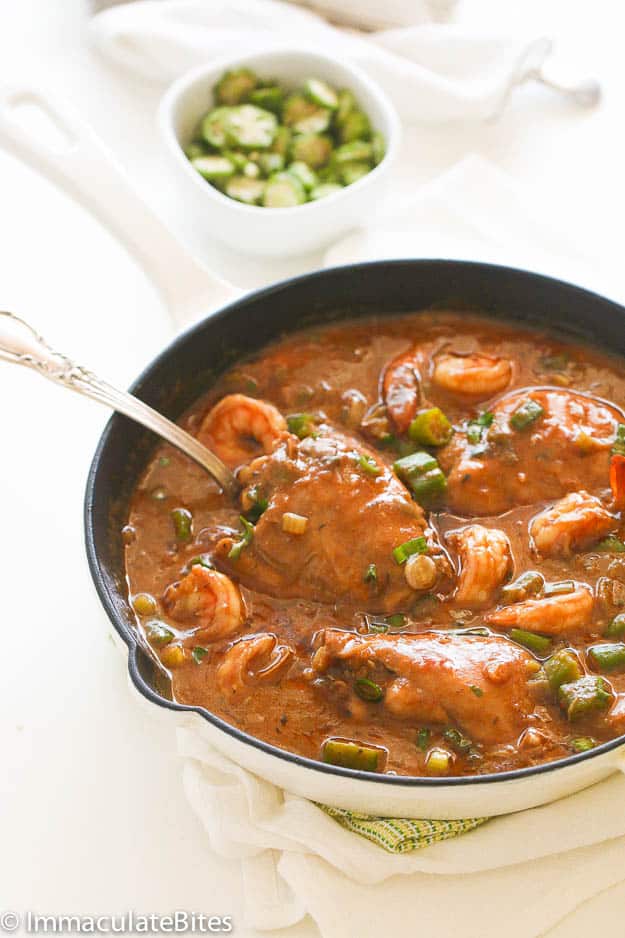 Chicken Shrimp and Okra Gumbo in a Skillet with a small bowl of chopped okra in the background