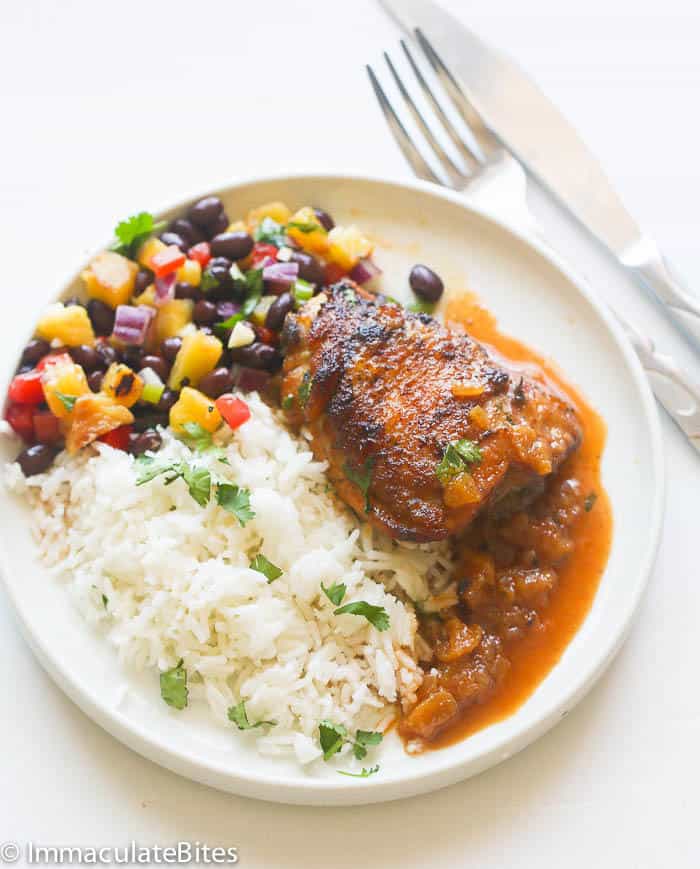A Plate of Pineapple Glazed Chicken Served with White Rice and Grilled Pineapple Black Bean Salsa