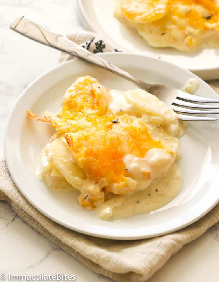 Enjoying Scalloped Potatoes on a white plate