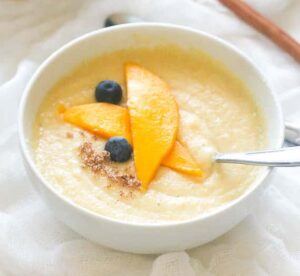 Jamaican cornmeal porridge with mango slices and blueberries