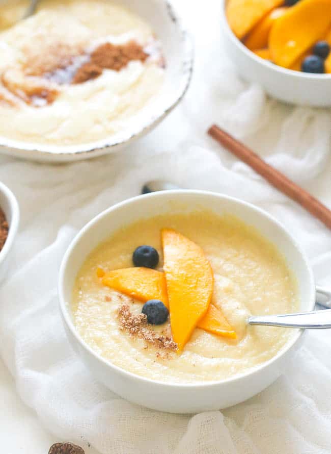 Jamaican cornmeal porridge with mango slices and blueberries