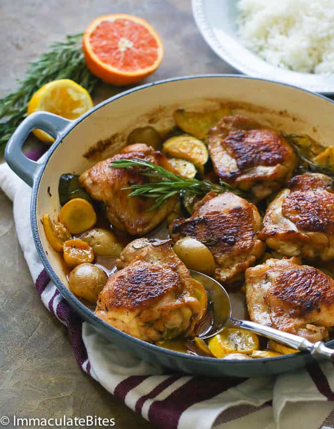 Rosemary Chicken in a Pan with Lemon and Orange Slices in the Background