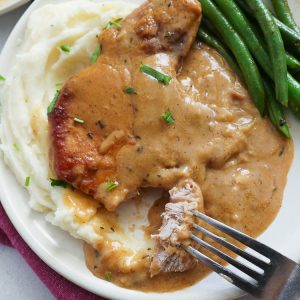 Mashed Potatoes topped with Smothered Pork Chops and Green Beans on the Side