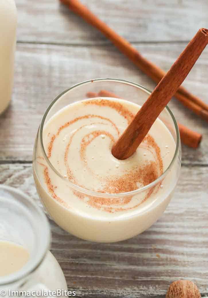 Coquito in a glass with a cinnamon stick