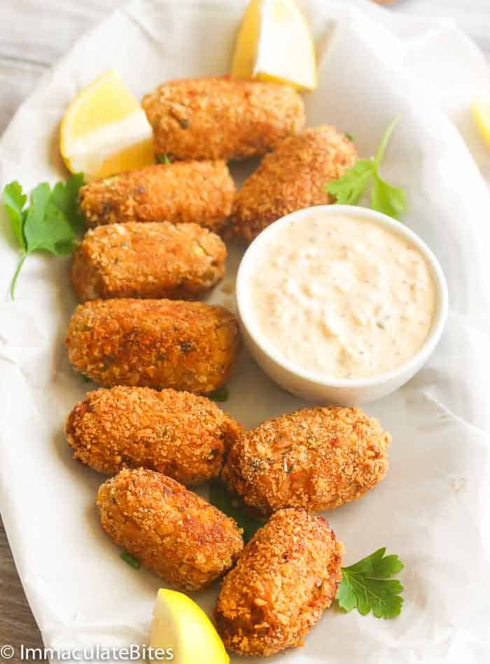 a platter of salmon croquettes with a saucer fill of remoulade sauce on the side