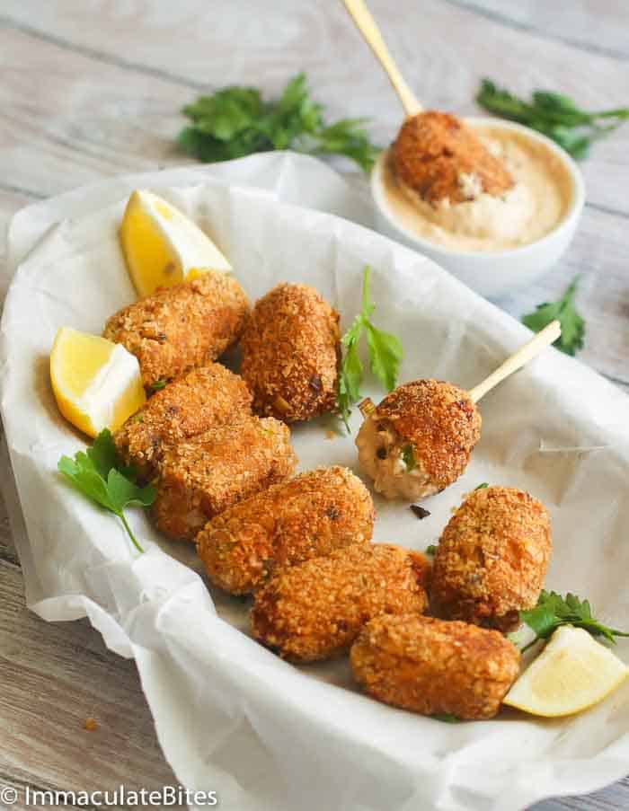 croquettes served on a dish with lemon wedges