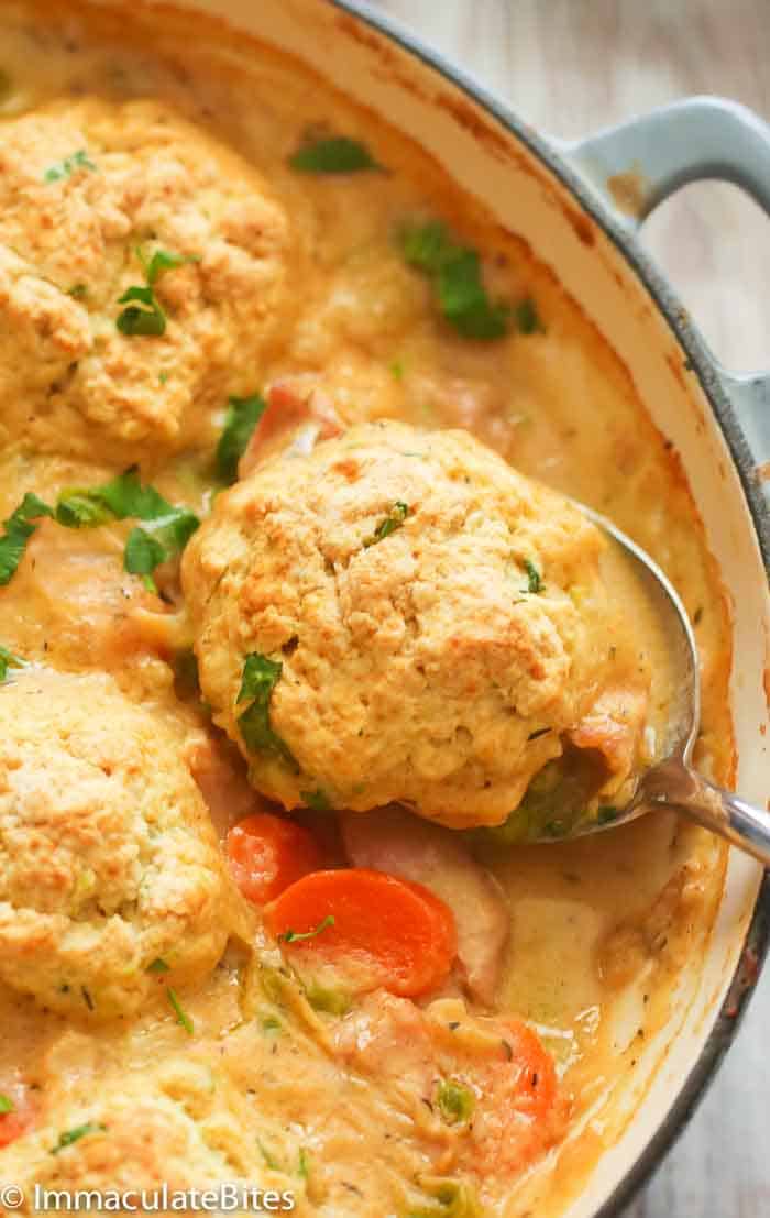A Pan of Chicken and Dumplings with a Spoon Scooping Out a Dumpling