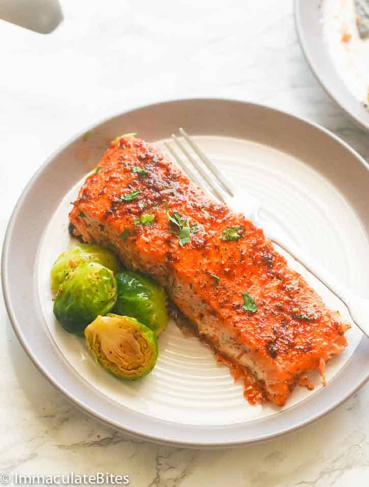 A tasty oven baked salmon fillet with roasted Brussels sprouts on a white plate