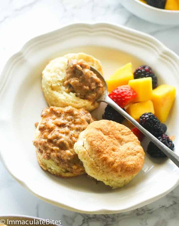 Biscuits sausage and gravy with a fruit salad for pure comfort food