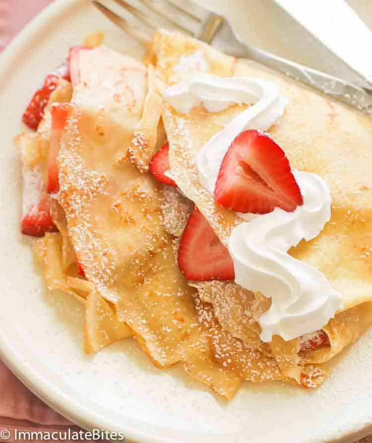 Easy Crepe recipe filled with whipped cream and fresh strawberries