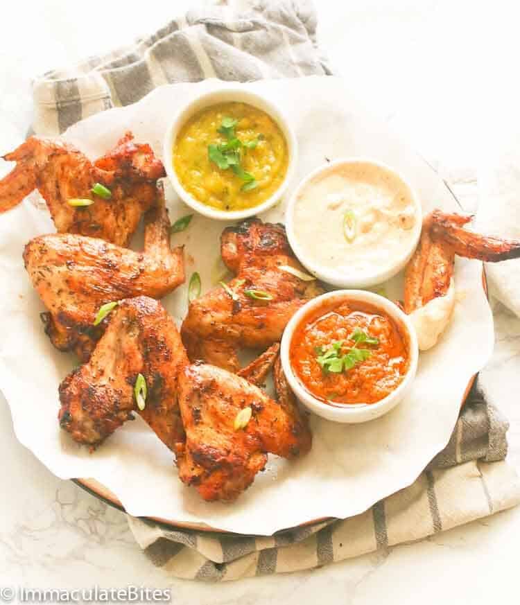 A Plate of Grilled Chicken Wings with Three Dips