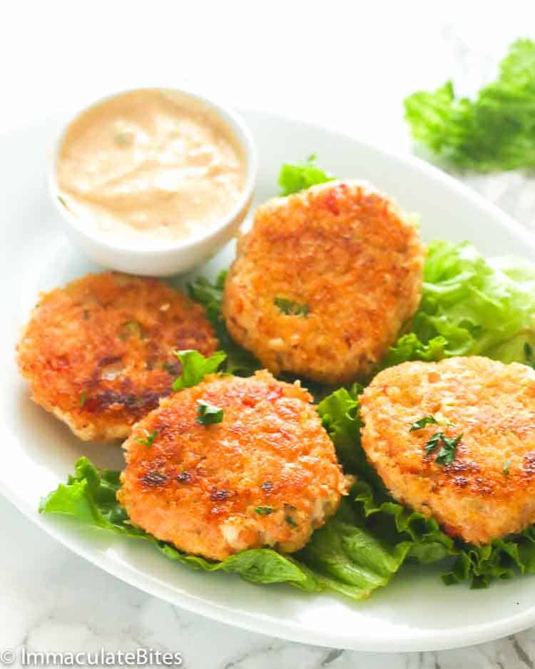Serving up fresh salmon patties on a bed of lettuce with remoulade on the side