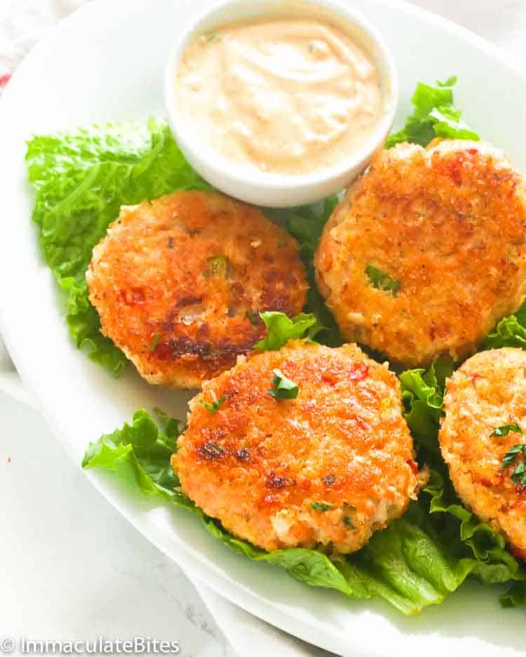 salmon patties on a bed of lettuce served with remoulade sauce