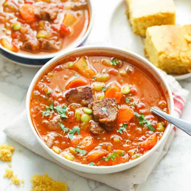 2 bowls of hearty vegetable beef soup served with cornbread