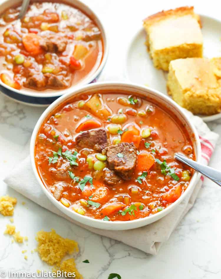 2 bowls of hearty vegetable beef soup served with cornbread